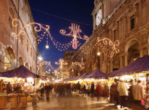 Italy,Lombardy,Milan,Christmas Market in street lined with people at dusk