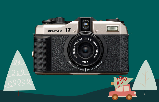 Stará filmová kamera Pentax 17 na tmavě zeleném pozadí s kreslenými vánočními stromky a autem s dárky Stará filmová kamera Pentax 17 na tmavě zeleném pozadí s kreslenými vánočními stromky a autem s dárky